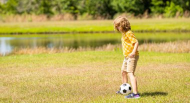 Çocuklar futbol oynarken iyi eğlenceler. Açık hava yaz aktivitesi. Çocuk dışarıdaki çocukluk maceralarını seviyor, uzay reklamlarını kopyalıyor. Çocukluğunda futbol oynayan bir çocuk. Çocukluk anıları..