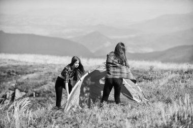 Neşeli hissediyorum. Arkadaşlar birlikte boş zaman geçirirler. Aile kampı. Hedefe ulaş. İki kız çadır kuruyor. Seyahat tutkusu keşfi. Doğa yürüyüşü macerası. dağ turizm kampı.