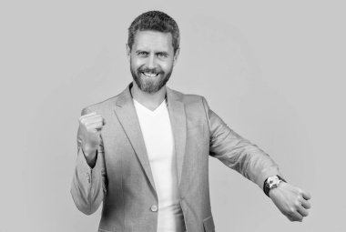 glad businessman follow punctuality with watch. businessman wearing watch. punctuality of businessman with watch in jacket isolated on yellow. businessman punctuality in studio. photo of handsome