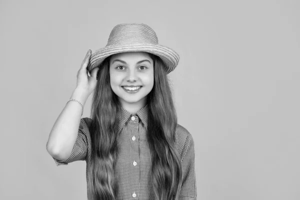 stock image happy child in straw hat on yellow background.