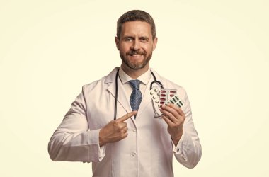 Haplı mutlu doktor. Adam beyaz hapları işaret ediyor. ilaç tedavisi.