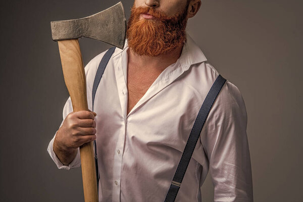 masculinity of man with axe in studio, cropped view. masculinity of man with axe on background. photo of masculinity of man with axe. masculinity of man with axe isolated on grey.