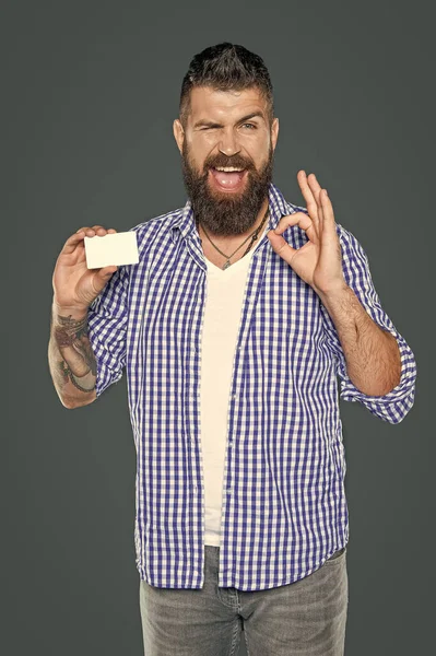 Neşeli sakallı adam, kopyalama alanı olan boş bir banka kartı gösteriyor.