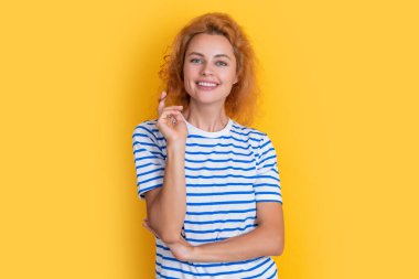 Sarı arka planda izole edilmiş mutlu kızıl saçlı kadın portresi. Stüdyodaki genç kızıl saçlı kadının portresi. Yetişkin kızıl kadın portresi.