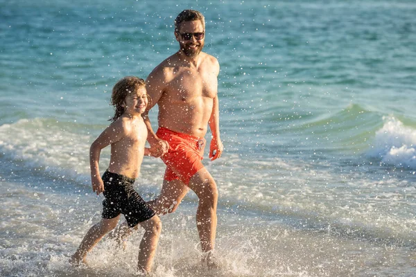 daddy and son running in sea beach. Father son child bonding enjoying summer vacation. Special moments between daddy and son at sea. Father son kid bonding relationship. horizons on summer vacation.