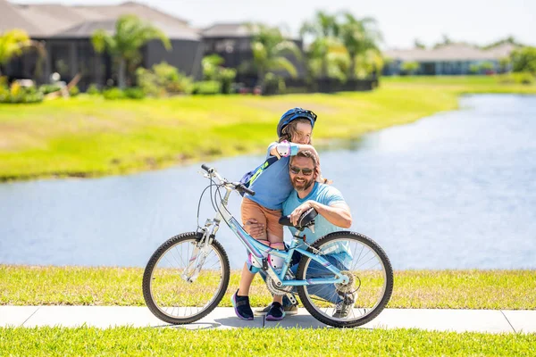active father setting a example for fathers son. fathers parenting with son outdoor. childhood of son supported by fathers care. father and son on bicycle at fathers day. Dad and kid adventures.
