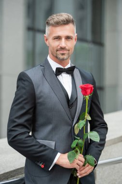 Nişan fikri. Smokinli adam nişanı kutluyor. Nişan için gül hediyeli bir adam.