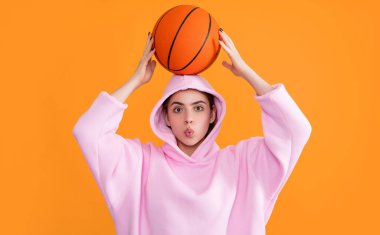 funny sporty girl with basketball ball on yellow background.