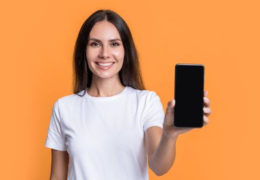 Ürünü kopyalama alanı ile sunmak, seçici odak. Cep telefonunu gösteren mutlu kadın. Gülümseyen bir kadın mobil cihaz sunuyor. Mobil teknoloji. Mobil iletişim.