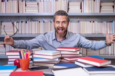 Okul öğretmeni kütüphanede eğitimi geliştirir. Bilgi günü. Öğretmen sınava hazırlan. Derste çok çalışan bir profesör. Kitaplı bir okul profesörü. Öğretmenler günü. Fazla çalışma.