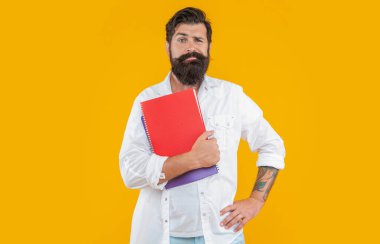 Stüdyodaki planlamacıyla milenyum adamını karıştırdım. Arkaplanda planlayıcısı olan bin yıllık bir adam. Milenyum adamı ve planlayıcısının fotoğrafı. Milenyum adamı planlayıcısı sarıda soyutlanmış..