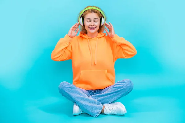 smiling woman has music lifestyle on background. photo of woman has music lifestyle wear headphones. woman has music lifestyle isolated on blue. woman has music lifestyle in studio.