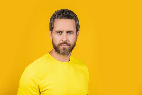 Stock image portrait of man wear yellow tshirt on background, copy space. man wear yellow tshirt in studio. photo of man wear yellow tshirt. man wear tshirt isolated on yellow.