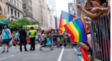 Gökkuşağı bayrağı Lgbt gururu. Eşcinsel gurur bayrağı sermaye çeşitliliğini sona erdirdi. Destekçiler gökkuşağı bayrakları sallıyor. LGBT örgütünün bayrağı lezbiyenler, geyler, biseksüeller ve transseksüeller içerir.