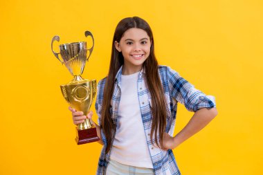 Genç kız gülümseyecek ve ödül kupasını sarıda izole edecek. Genç kız stüdyoda ödül alıyor. Genç kız arka planda ödülü kabul ediyor. Şampiyon kupa ödüllü gururlu genç kız..