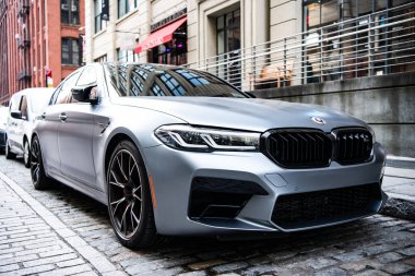 New York, ABD - 15 Temmuz 2023: BMW F90 M5 gri renkli araç park edilmiş, köşe manzaralı.