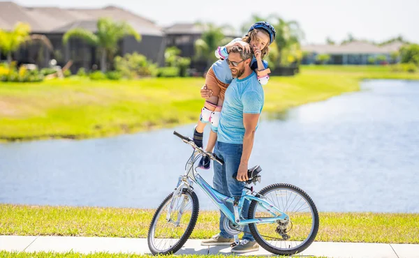 daddy and son spend time together. Strong family bonds. happy son and daddy cycling on bicycle. daddy teaching his son child to ride a bicycle. daddy and son kid outdoor.