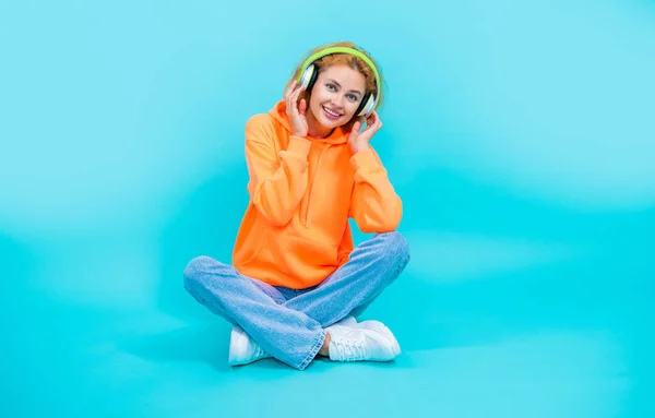 stock image full length of woman has music lifestyle in studio. woman has music lifestyle on background. photo of woman has music lifestyle wear headphones. woman has music lifestyle isolated on blue.