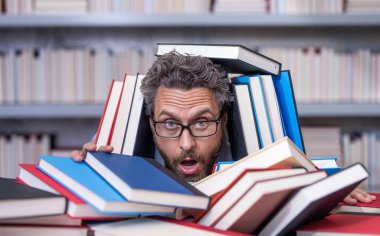 Çok çalışan milenyum öğrencisi kitap okuyor. Kitapçıda ya da okul kütüphanesinde kitap okuyan çok çalışan bir öğrenci. Okulda edebiyat öğretmeni ve kitap. Bilgi günü. Okul sınavına hazırlan..