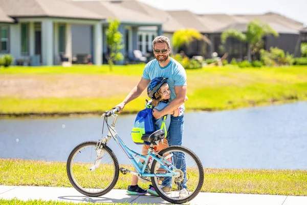 father and son on bicycle at fathers day. active father setting a example for fathers son. fathers parenting with son outdoor. Fatherly love and care. childhood of son supported by fathers care.