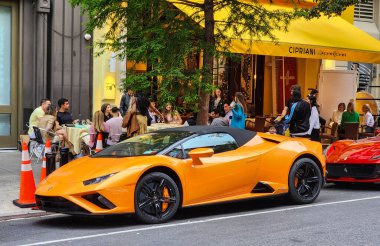 New York City, ABD - 3 Haziran 2023: Lamborghini Huracan LP 640-4 Performante üstü açık turuncu araba yan manzarası park edilmiş.