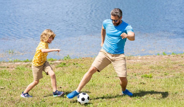 Childhood memories of son and his dad. dad have fun with his son. discovering fatherhood. dad and son enjoying childhood adventures outdoor. dad and son playing football during their childhood.