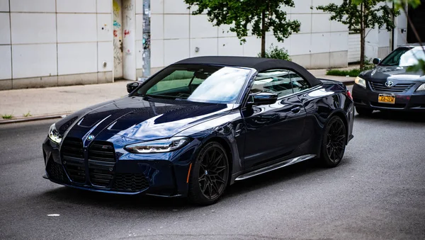 Stock image New York City, USA - July 23, 2023: 2023 BMW M4 Competition metal blue convertible car, front side view, circulating in a street