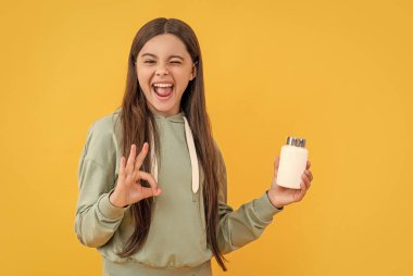 Stüdyoda ilaç tedavisi gören genç bir kız, geçmişinde ilaç olan genç bir kız. İlaç hapı almış genç bir kızın fotoğrafı. İlaçlı genç kız sarıda izole edilmiş..