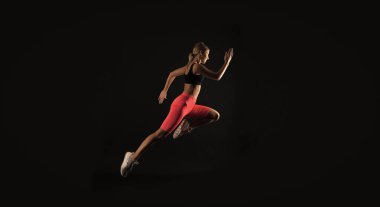 Stüdyoda kadın sporcu, dayanıklılık. Kadın sporcu arka planda. Spor kıyafetleri giyen kadın sporcunun fotoğrafı. Kadın sporcu siyah üzerine izole edilmiş..