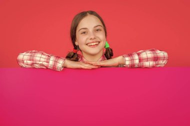 Reklam için fotokopi alanı olan pembe kağıdın arkasında mutlu bir çocuk..