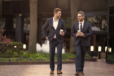 Takım elbiseli bir yönetici kahve içme işini tartışıyor. Yöneticinin kahve içerken çekilmiş bir fotoğrafı. Yönetici sokakta iş konuşuyor. yönetici iş görüşmeleri