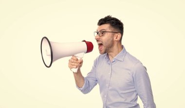 Kızgın adam, beyaz arka planda izole edilmiş megafonla anons yapıyor. Adam stüdyoda megafonla anons yapıyor. Bağıran adam megafonla anons yapıyor. Megafonla anons yapan adamın fotoğrafı..