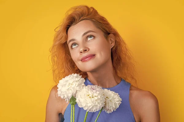 dreamy woman with spring flowers isolated on yellow. woman with spring flowers in studio. woman with spring flowers on background. photo of woman with spring flowers.