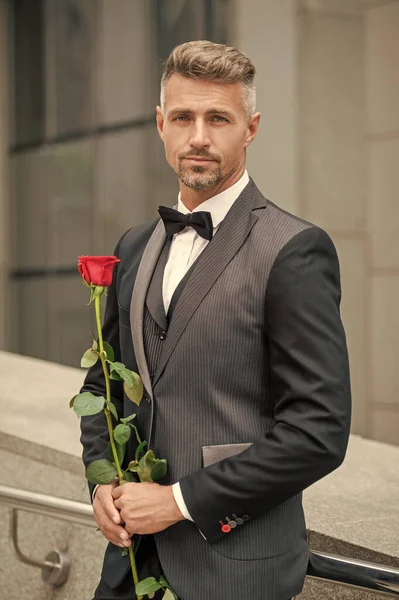 engagement concept. romantic tuxedo man celebrating engagement. man with rose gift for engagement.
