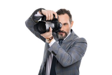 Kameralı iş fotoğrafçısı. Gazeteci, beyazın üstünde tek başına fotoğraf çekiyor. Paparazzi fotoğrafçı. İş adamı fotoğraf makinesini tutar. Takım elbiseli foto muhabiri. fotoğraf muhabiri.