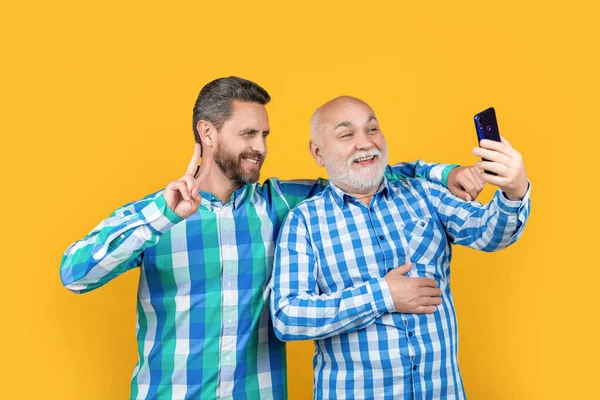 generation men make video in studio, peace. generation men make video on background. photo of generation men make video on phone. generation men make video isolated on yellow.