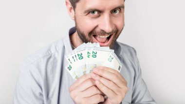 Stüdyoda para kazanan gülümseyen adam. Para kazanan banknotları olan bir adam. Para kazanan bir adamın fotoğrafı. Para kazanan bir adam stüdyo geçmişinde izole edilmiş..