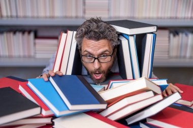 Çok çalışan milenyum öğrencisi kitap okuyor. Çalışkan erkek öğrenci bir kitapçıda ya da okul kütüphanesinde kitap okuyor. Okulda edebiyat öğretmeni ve kitap. Bilgi günü. Okul sınavına hazırlan..