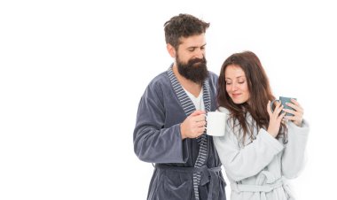 Man and woman wear bathrobes hold tea mug or coffee cup. Caffeine power concept. With coffee morning tastes better. Couple relax in morning with coffee. Couple enjoy lazy weekend and drink coffee.