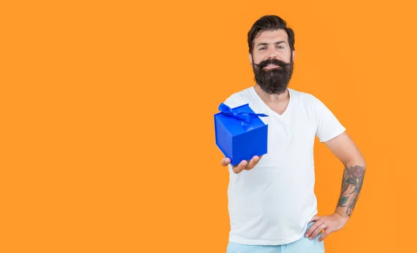 stock image man on birthday shopping, copy space. bearded man go shopping for birthday. man in studio with birthday gift. shopping concept. birthday shopping of man isolated on yellow background.