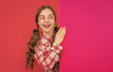 Boş pembe kağıdın arkasında reklam için fotokopi alanı olan bir çocuk..