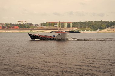 Manaus, Brezilya - 04 Aralık 2015: römorkör küçük tekneyi çekiyor.