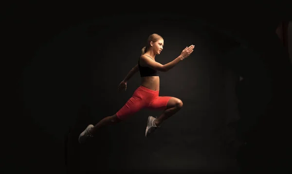 woman sport runner isolated on black. woman sport runner in studio. woman sport runner on background. photo of woman sport runner wearing sportswear.