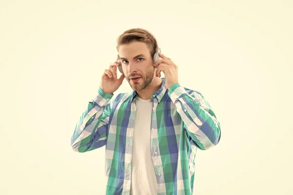 millennial man wear music headphones and checkered shirt in studio. millennial man listening music on background. photo of millennial man music lover. millennial man listen music isolated on white.