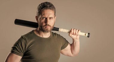 hooligan man with bat isolated on grey background, copy space. hooligan man with bat in studio. photo of hooligan man with bat. hooligan man threatening with bat.