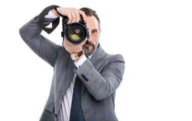 Paparazzi fotoğrafçı. İş adamı fotoğraf makinesini tutar. Takım elbiseli foto muhabiri. Kameralı iş fotoğrafçısı. Gazeteci, beyazın üstünde tek başına fotoğraf çekiyor. Boşluk afişini kopyala.