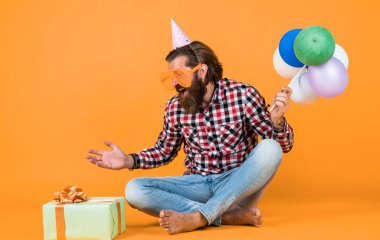 Başarıyı hisset. Doğum günü şapkalı neşeli adam tatil balonları tutuyor. Hediyeler ve hediye konsepti. İyi tatiller. Parti zamanı. Doğum günün kutlu olsun. Sakallı olgun adam doğum günü partisini kutluyor..