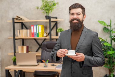 İş adamı kılığındaki acımasız CEO gülümsemesi sabah kahvesini ofiste tutar, başarıdır..