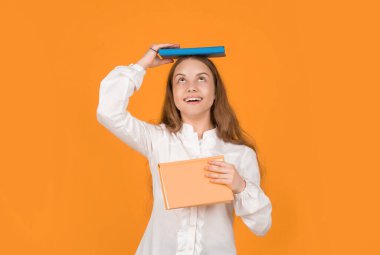 Genç kız ödevlerini defterle yapıyor. Çalışma kitabıyla çalış. Büyülenmiş çocuk kitabı. Okula dönüyorum. Çocukluk eğitimi. Bilgi günü. Çocuk defteri tut. Lise öğrencisi..