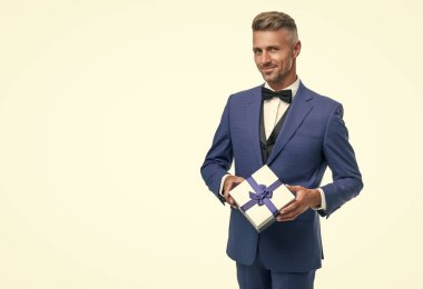 glad man in blue suit with gift box isolated on white. valentines day.